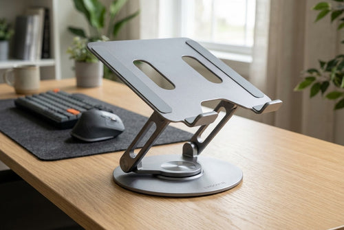 ErgoVue Apex 360 rotating aluminium riser in matte silver, raising a laptop to eye level